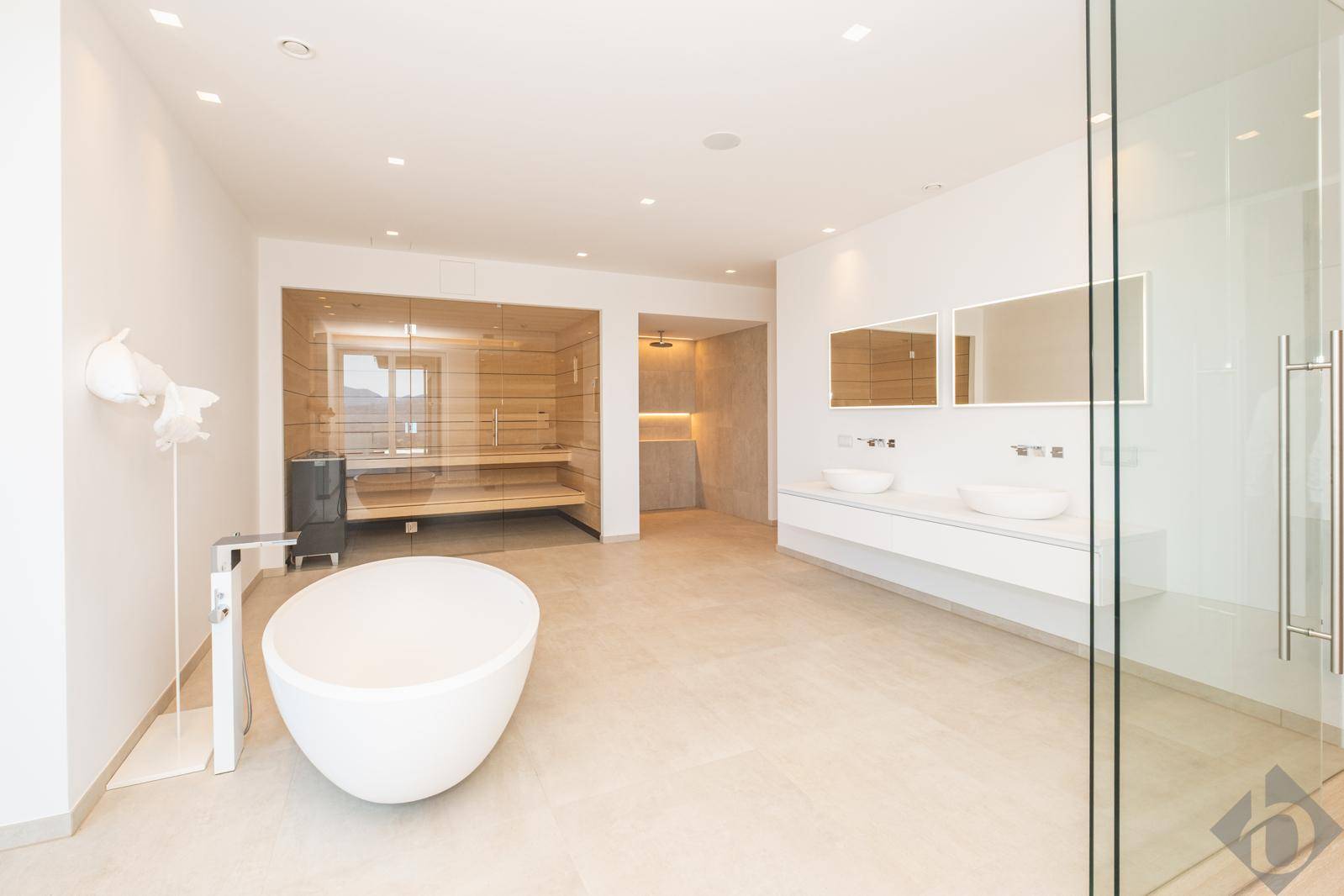Luxuriöses Badezimmer mit freistehender Badewanne, Doppelsink, begehbarer Dusche und Sauna.