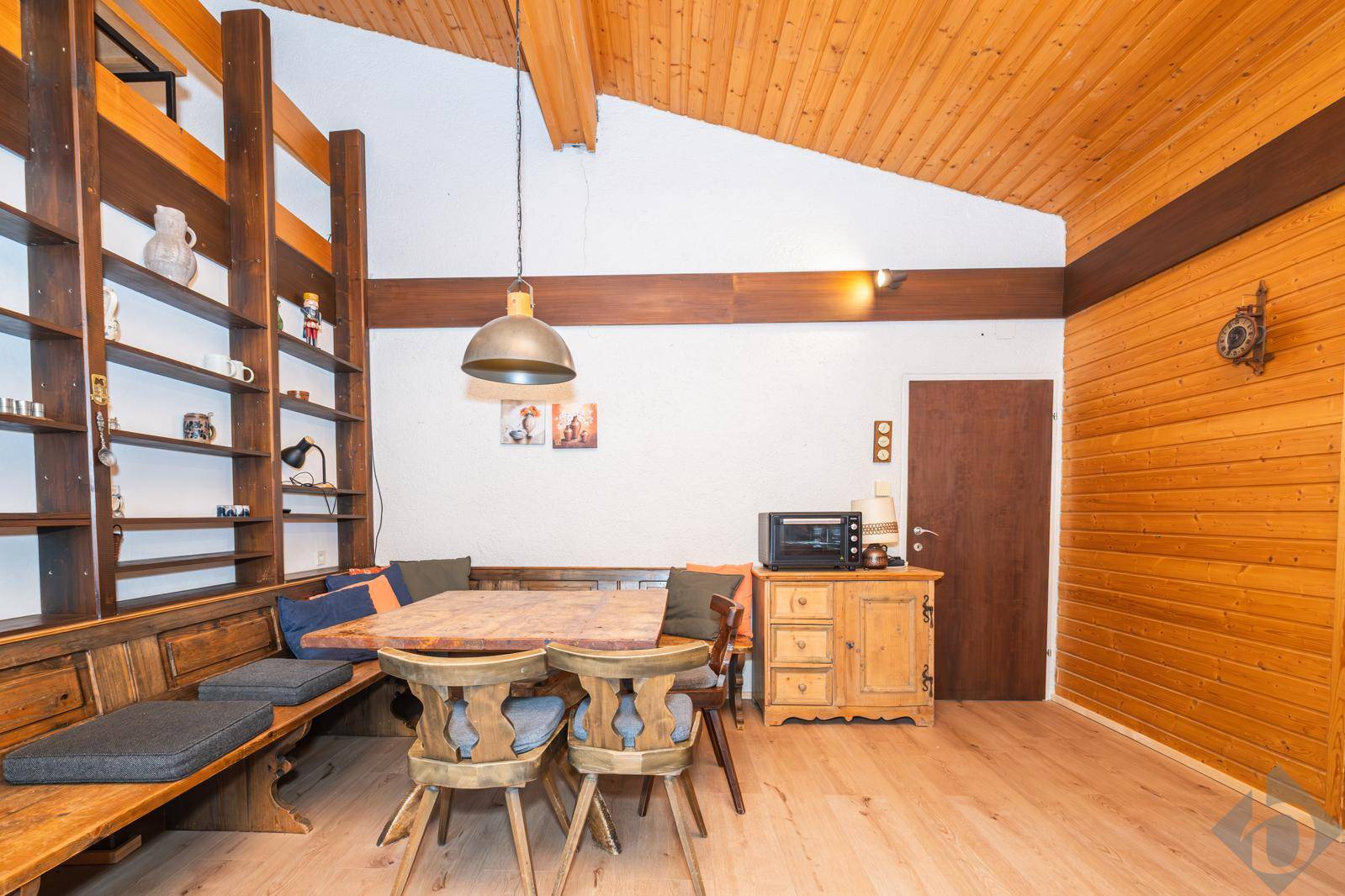 Gemütlicher Essbereich im alpinen Stil mit Holzwänden, Holzbalkendecke und integrierten Sitzbänken.
