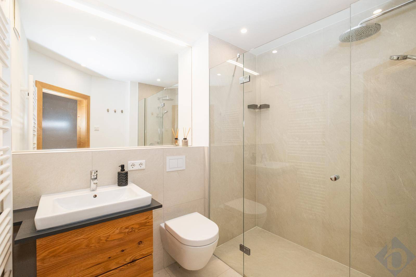 Elegantes Badezimmer mit begehbarer Dusche, Regendusche und beheiztem Handtuchhalter.