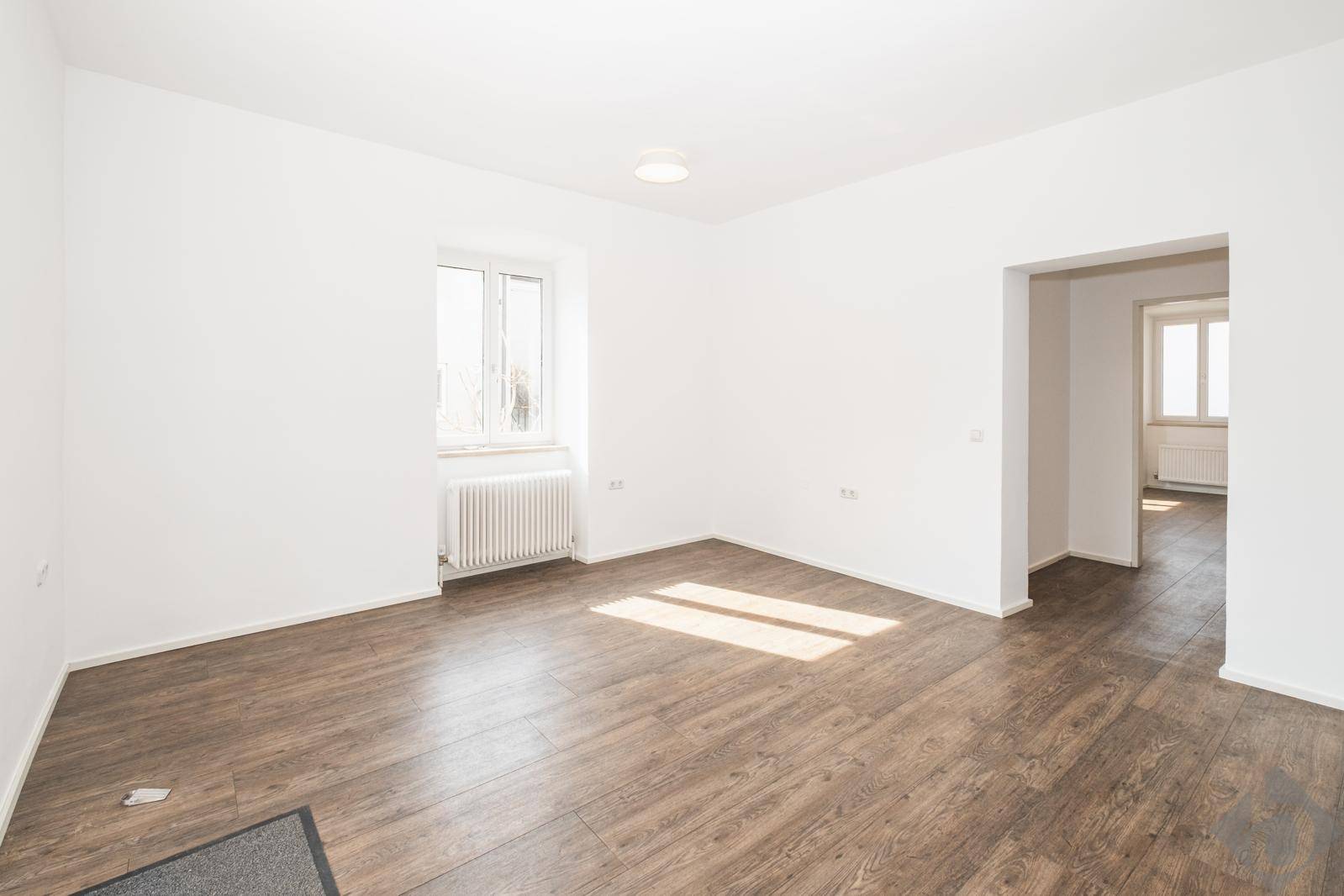 Geräumiger, heller Wohnbereich mit Laminatboden und viel Tageslicht durch das Fenster.