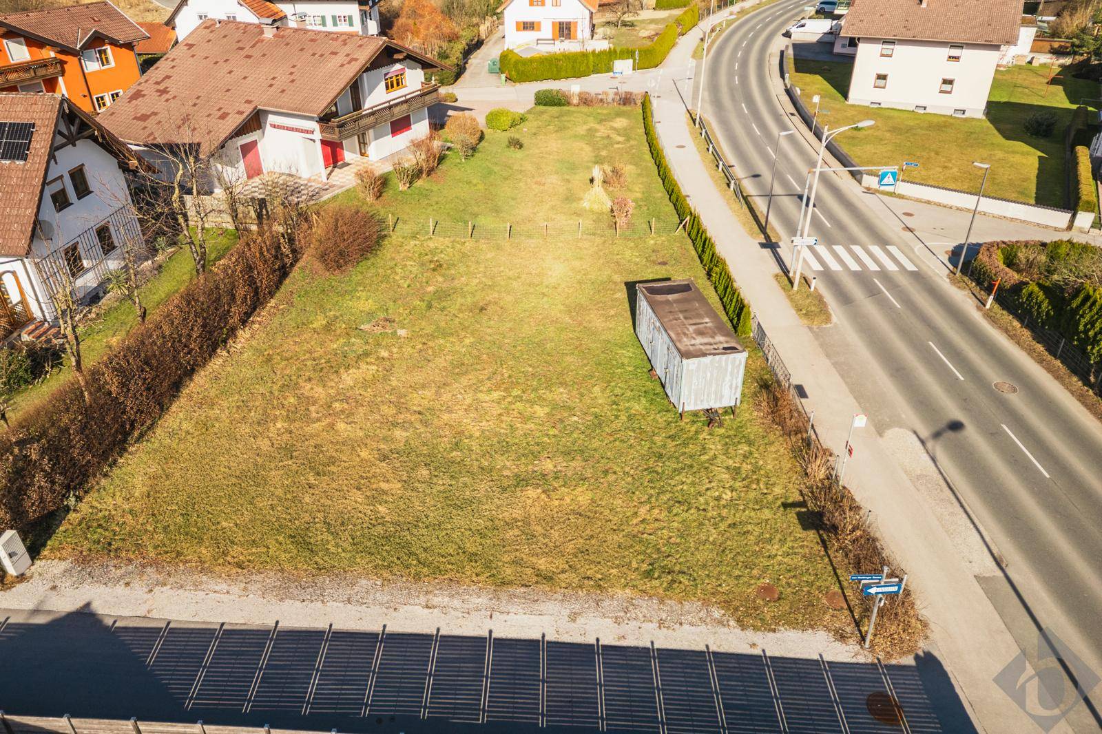 Übersicht aus der Vogelperspektive auf das Baugrundstück, die angrenzende Straße und die Nachbarschaft.