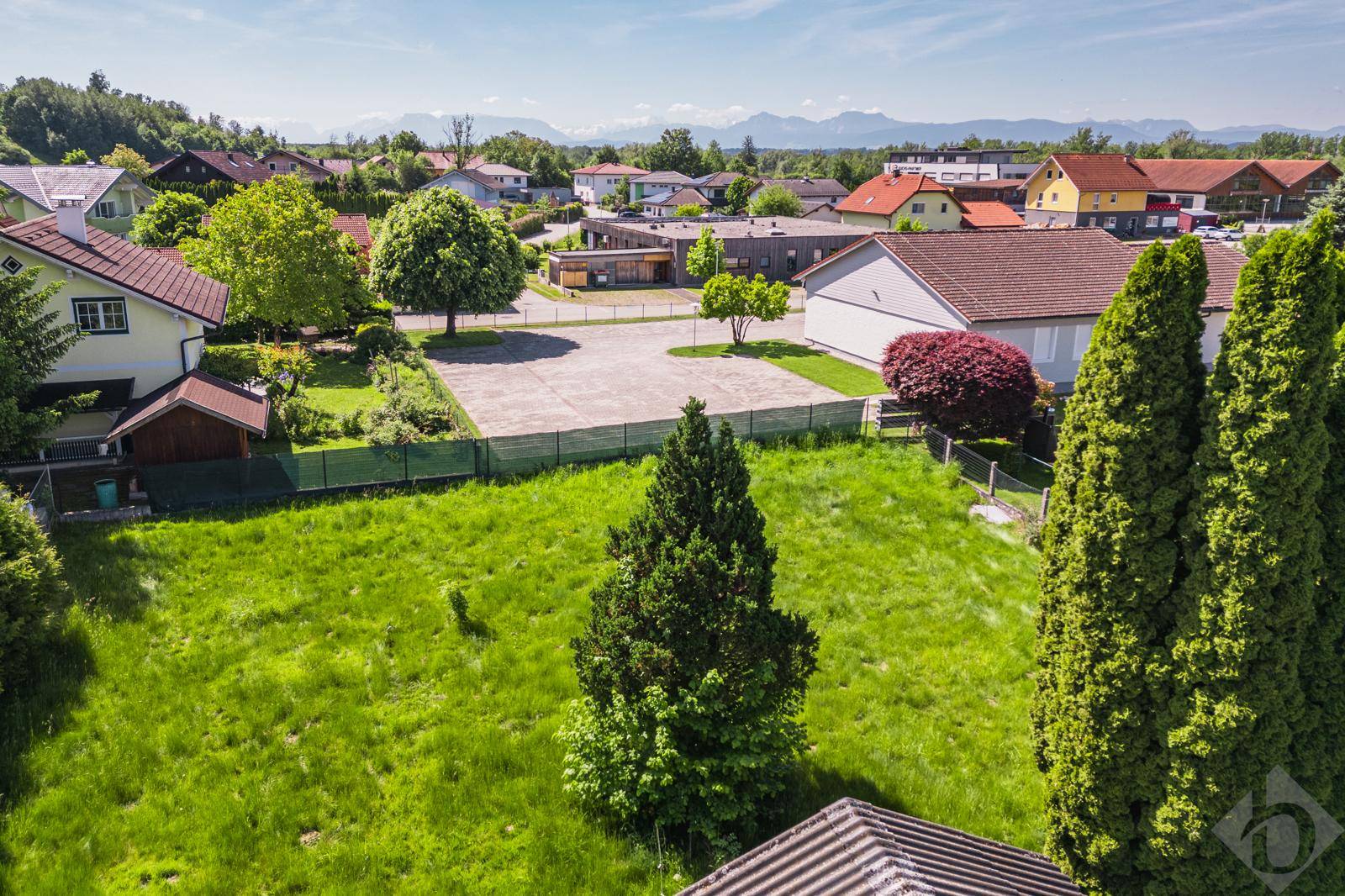 Weitläufiges Grundstück mit Blick auf die umliegende Wohnbebauung und ferne Berge.