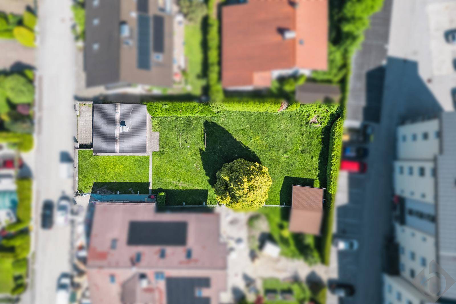Senkrechte Luftaufnahme eines Grundstücks mit Haus, Garten und Nebengebäude in Wohngegend.