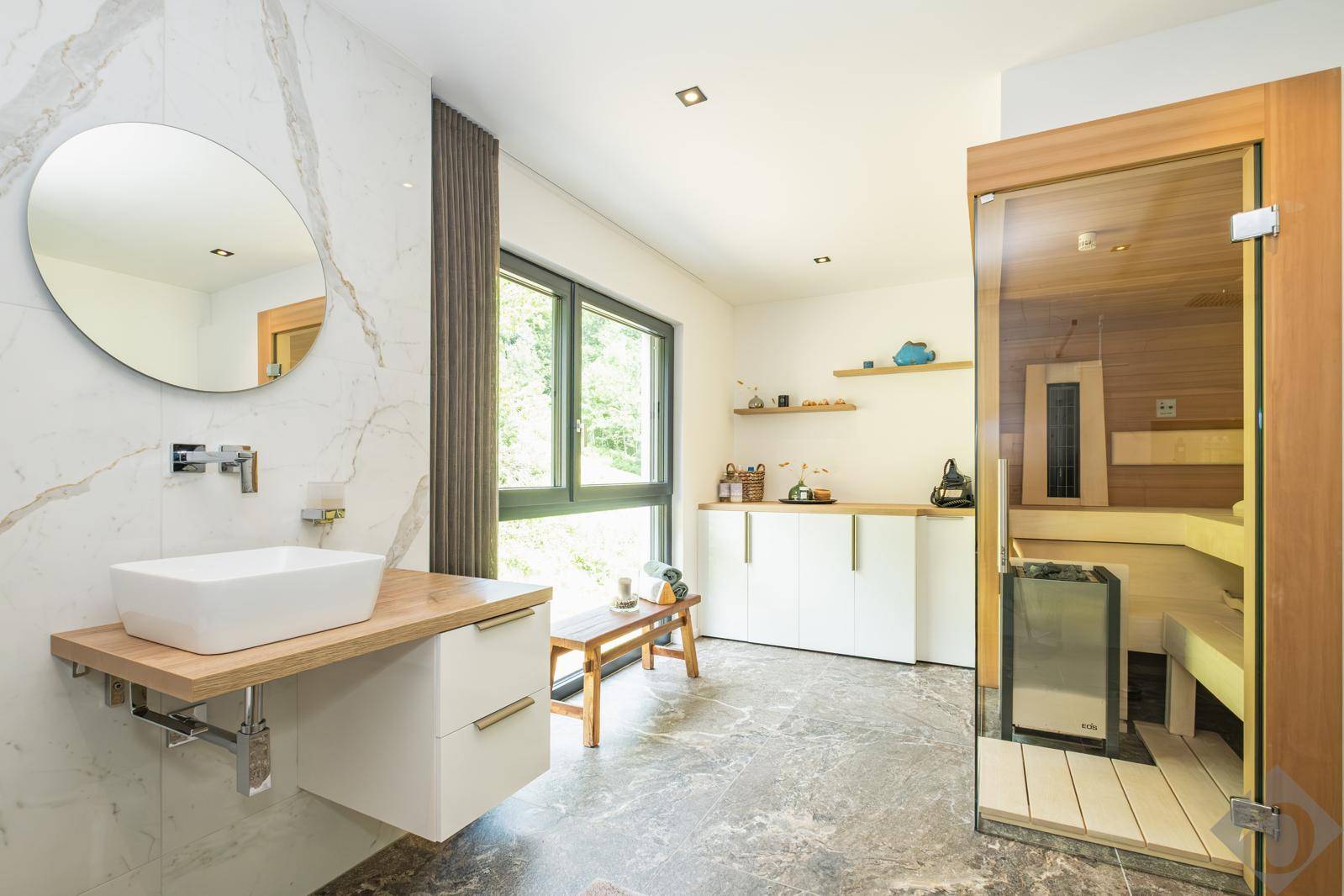 Modernes Badezimmer mit Waschtisch, Fenster und integrierter Sauna für entspannende Momente.