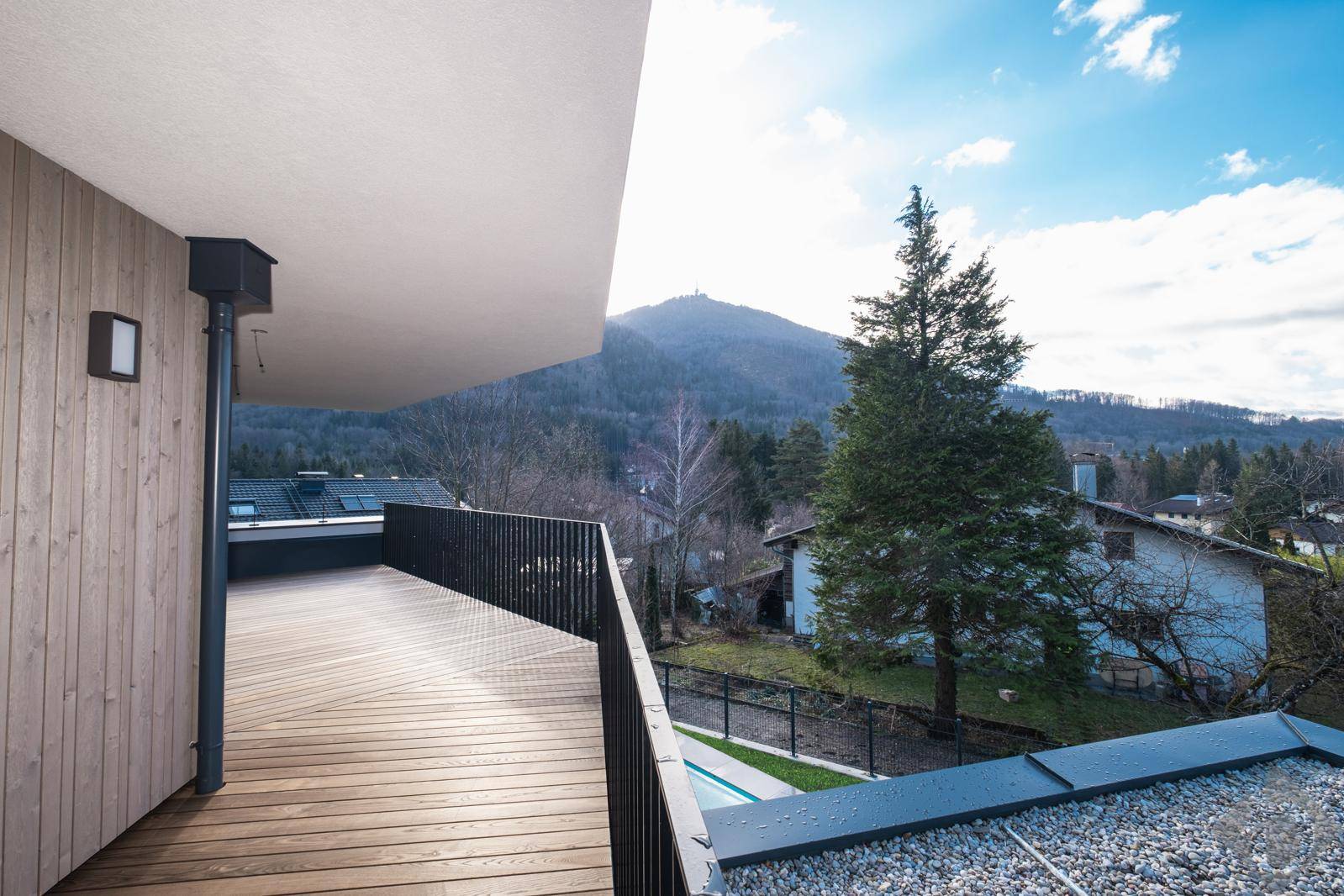 Geräumiger Balkon mit Holzbelag und weitem Blick auf die umliegende Berglandschaft.