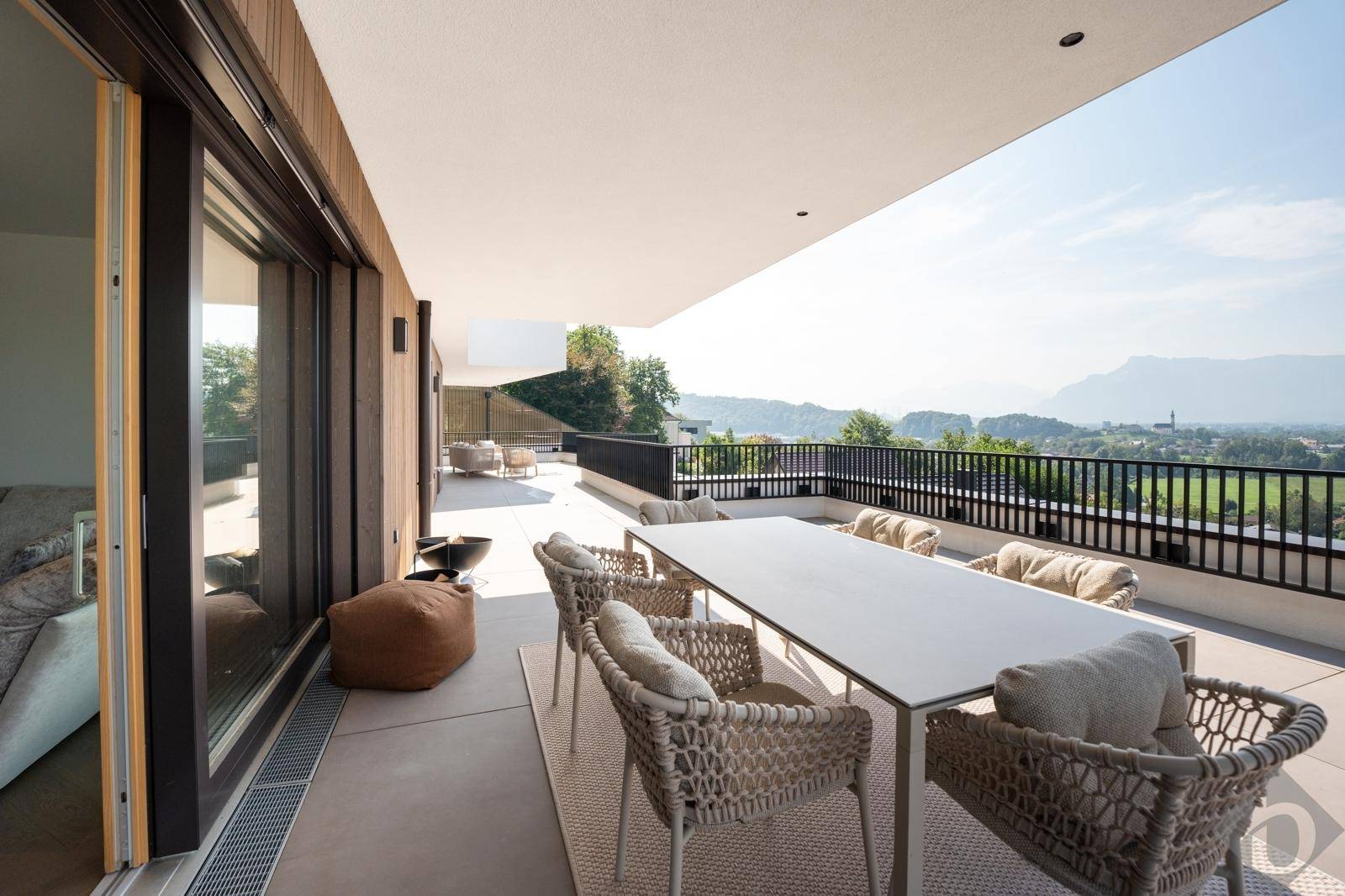 Große, sonnige Terrasse mit Esstisch, bequemen Sitzgelegenheiten und weitem Blick auf die Landschaft.
