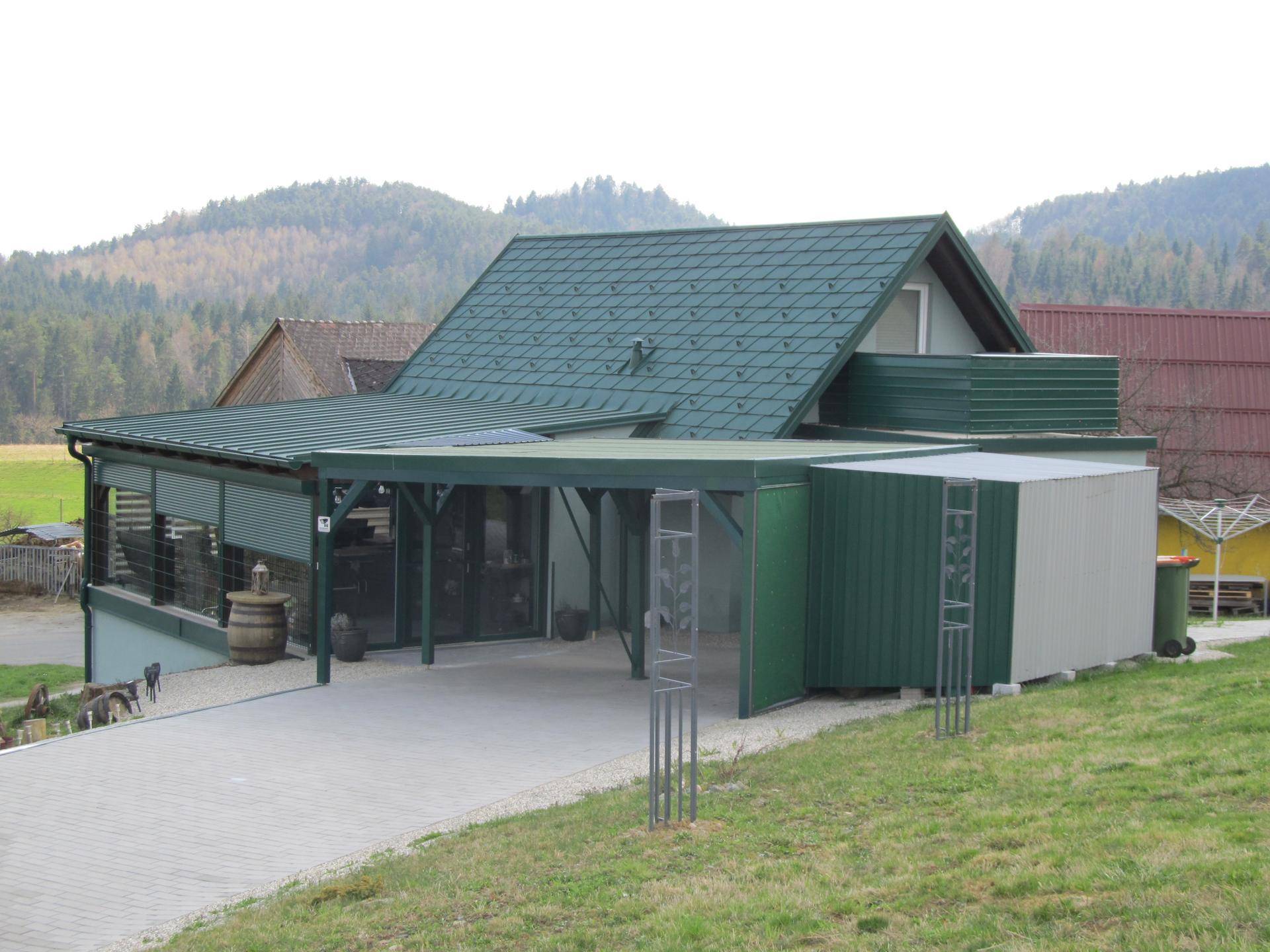 Haus mit Carport und Anbau in ländlicher Umgebung mit Bergblick.