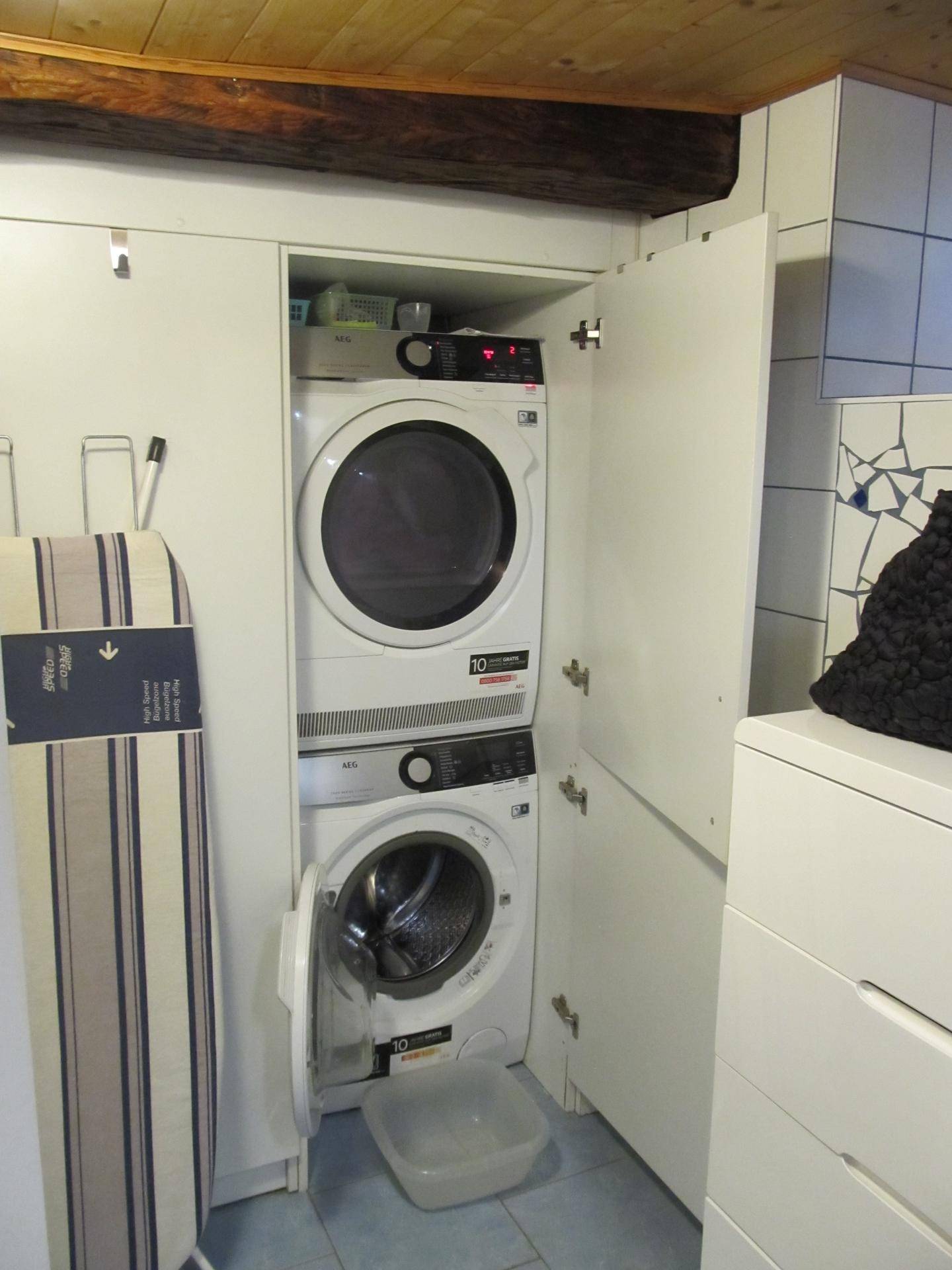 Praktischer Waschbereich mit gestapelter Waschmaschine und Trockner in einem Schrank.
