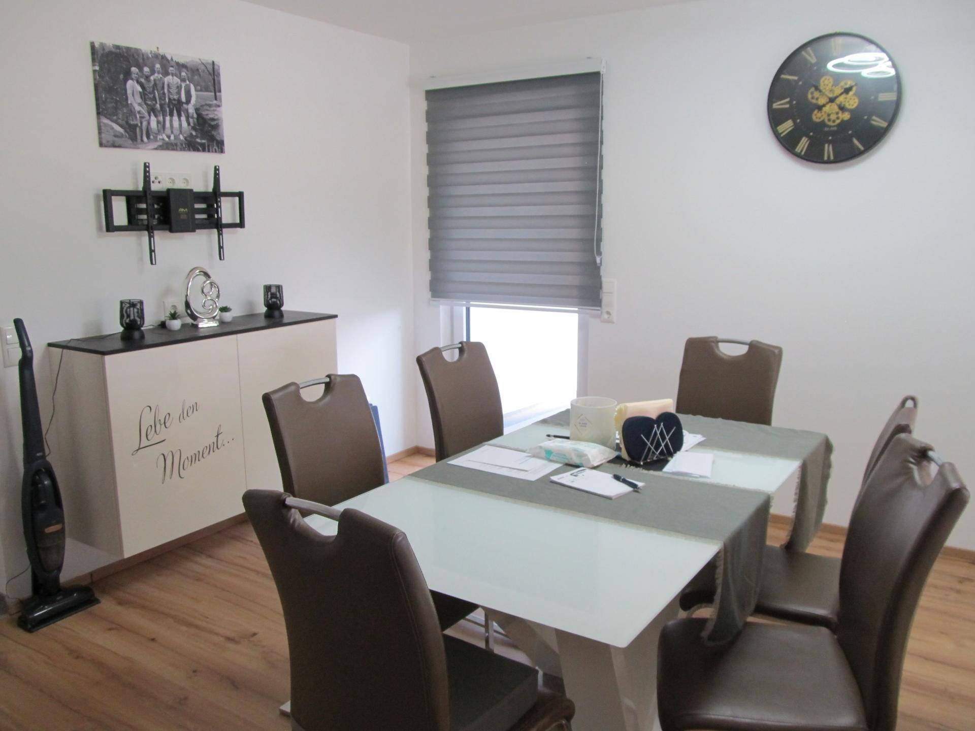 Esszimmer mit modernem Esstisch, braunen Stühlen und Laminatboden.