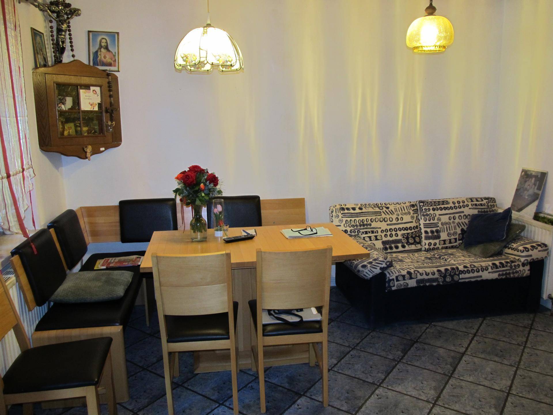 Gemütlicher Wohn-Essbereich mit Esstisch, Sofa und gefliestem Boden, traditionell eingerichtet.