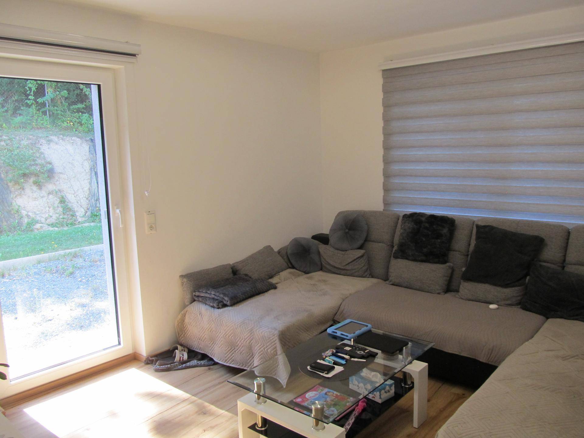Gemütliches Wohnzimmer mit großem Ecksofa, Couchtisch und Zugang zum Außenbereich.