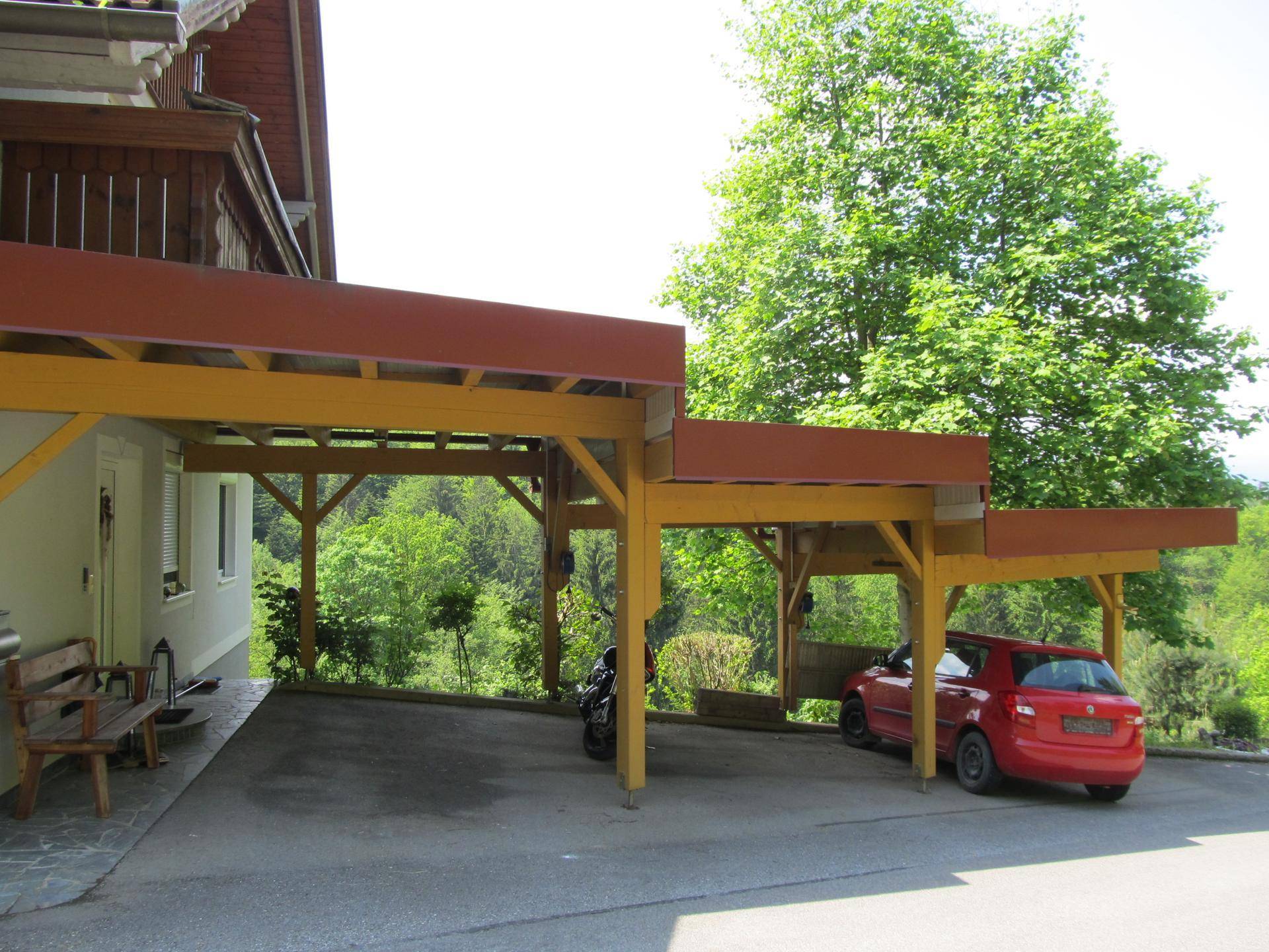 Geräumiger Holzcarport mit Platz für zwei Fahrzeuge und Blick ins Grüne.