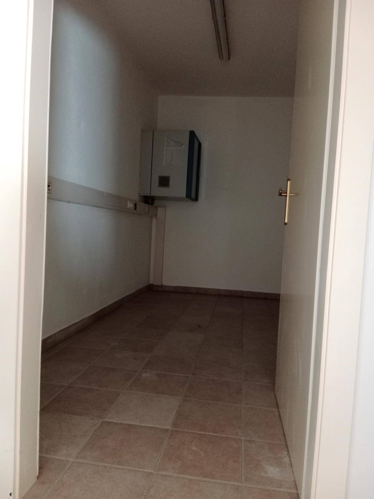 Schmaler Abstellraum mit Fliesenboden und einer Wandinstallation, ideal für Lagerzwecke oder Technik.