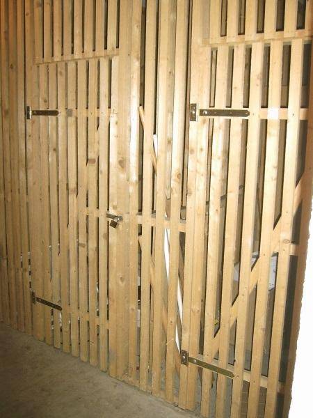 Praktische Holzverschläge für zusätzlichen Stauraum in einem Kellerabteil.