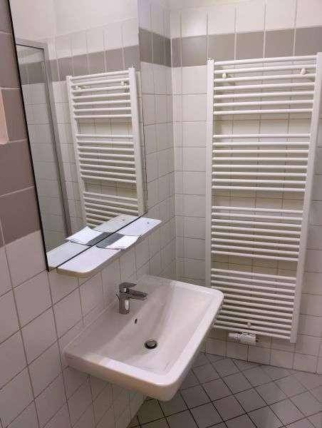 Badezimmer mit Waschbecken, Spiegel und beheiztem Handtuchhalter.
