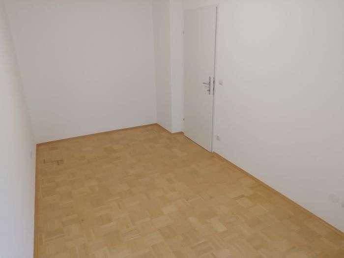 Weiteres helles Zimmer mit Parkettboden und weiß gestrichenen Wänden, vielseitig nutzbar.