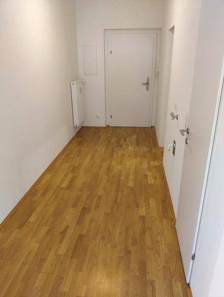 Langer, heller Flur mit Parkettboden und Zugang zu den verschiedenen Wohnbereichen der Wohnung.