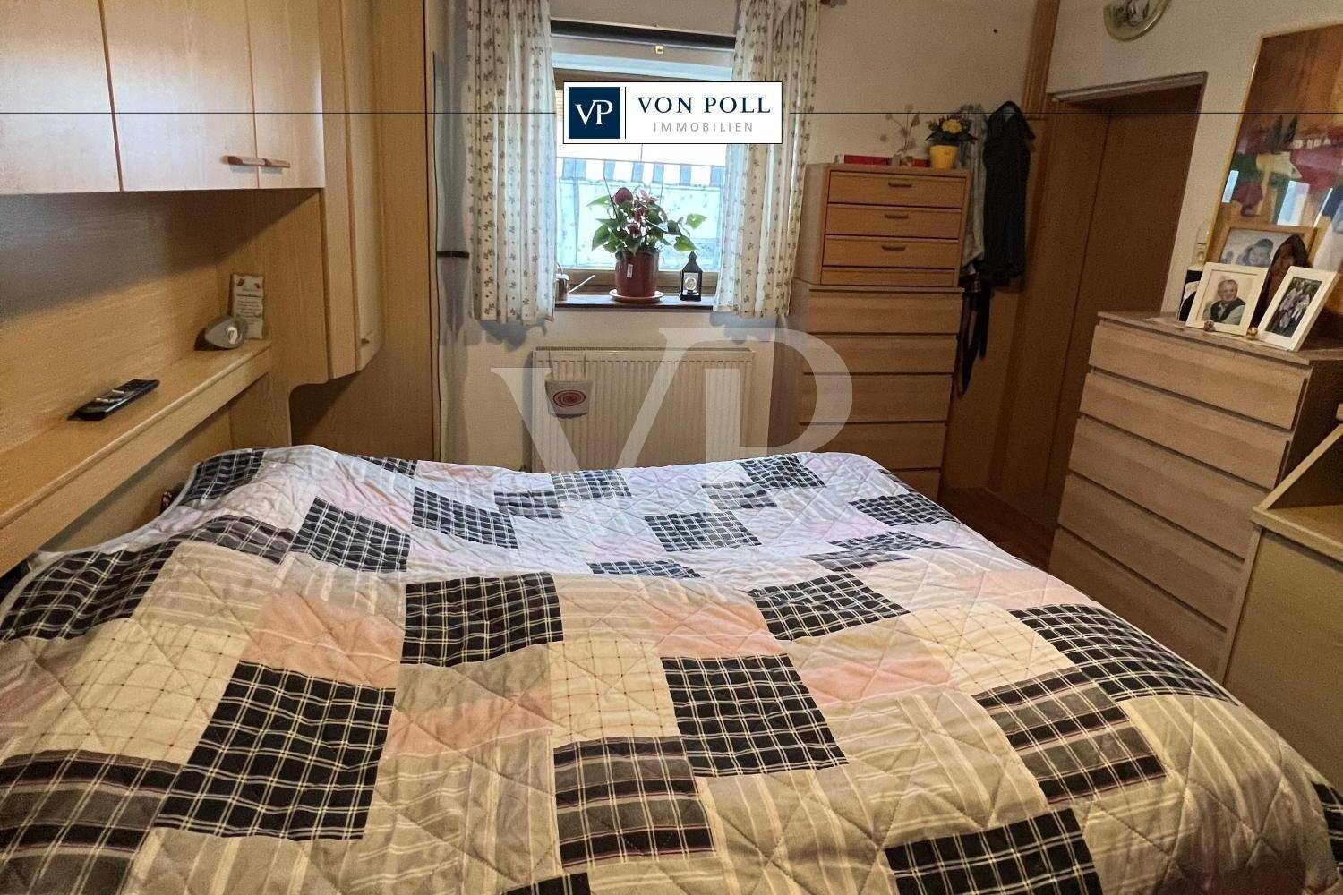 Gemütliches Schlafzimmer mit Doppelbett, Holzmöbeln und Fenster mit Blick ins Grüne.