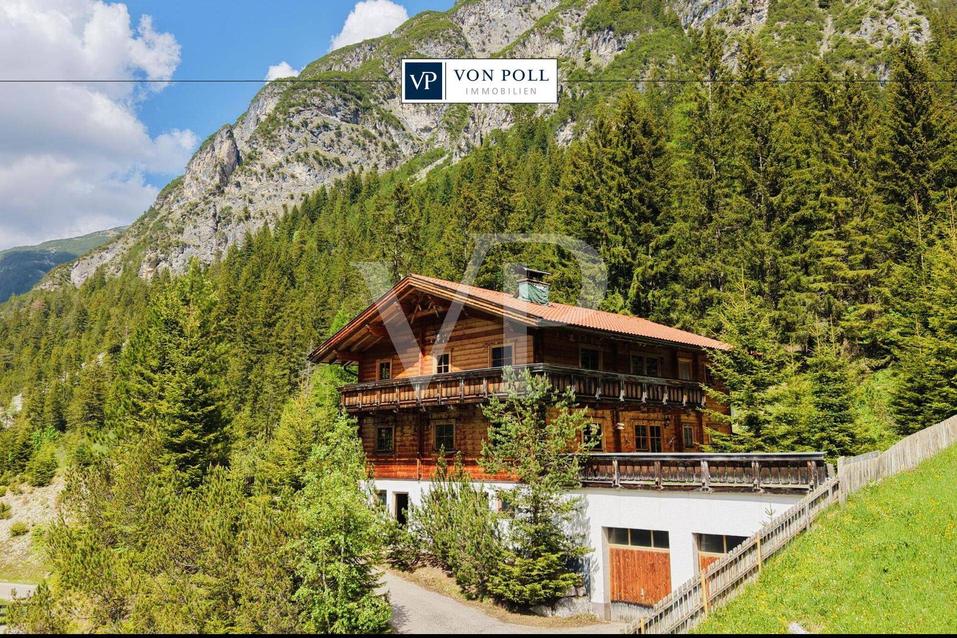Großzügiges Holzchalet mit mehreren Balkonen und integrierter Garage, eingebettet in die alpine Landschaft.