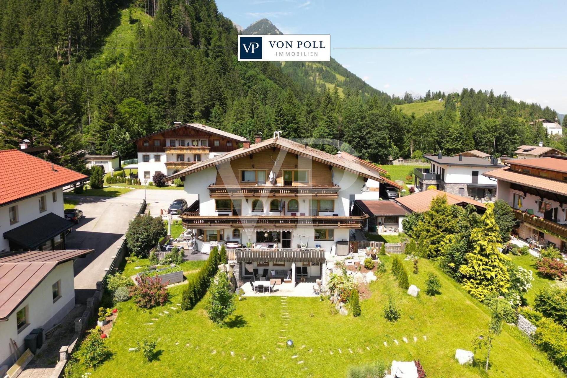 Alpenländisches Anwesen mit großem Garten und Bergblick, eingebettet in eine grüne Umgebung.
