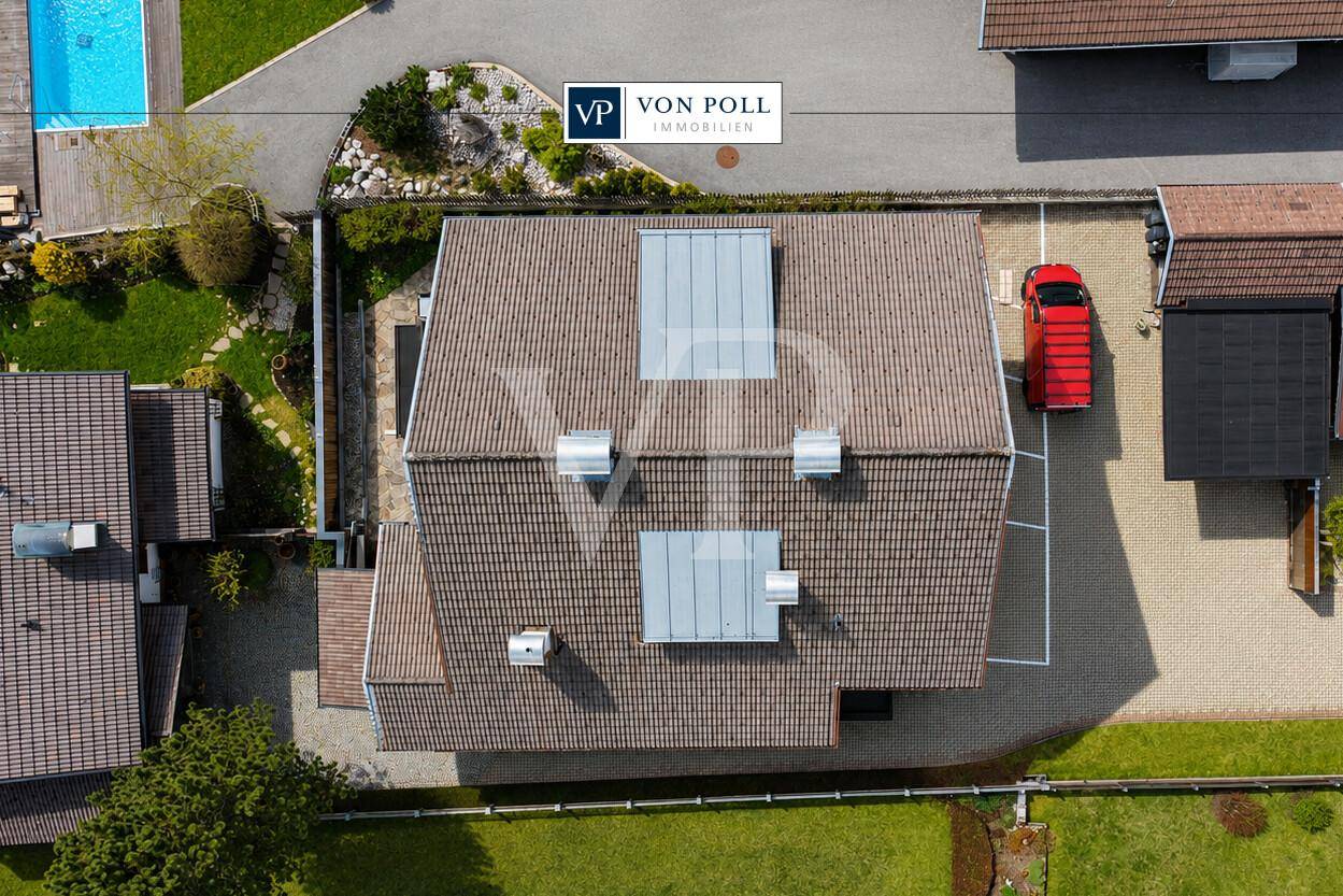 Luftaufnahme des Gebäudes mit Satteldach, angrenzendem Poolbereich und Parkplatz.