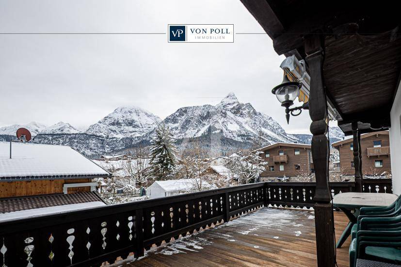 Großer Holzbalkon mit Sitzgelegenheiten und atemberaubendem Blick auf die schneebedeckten Berge.