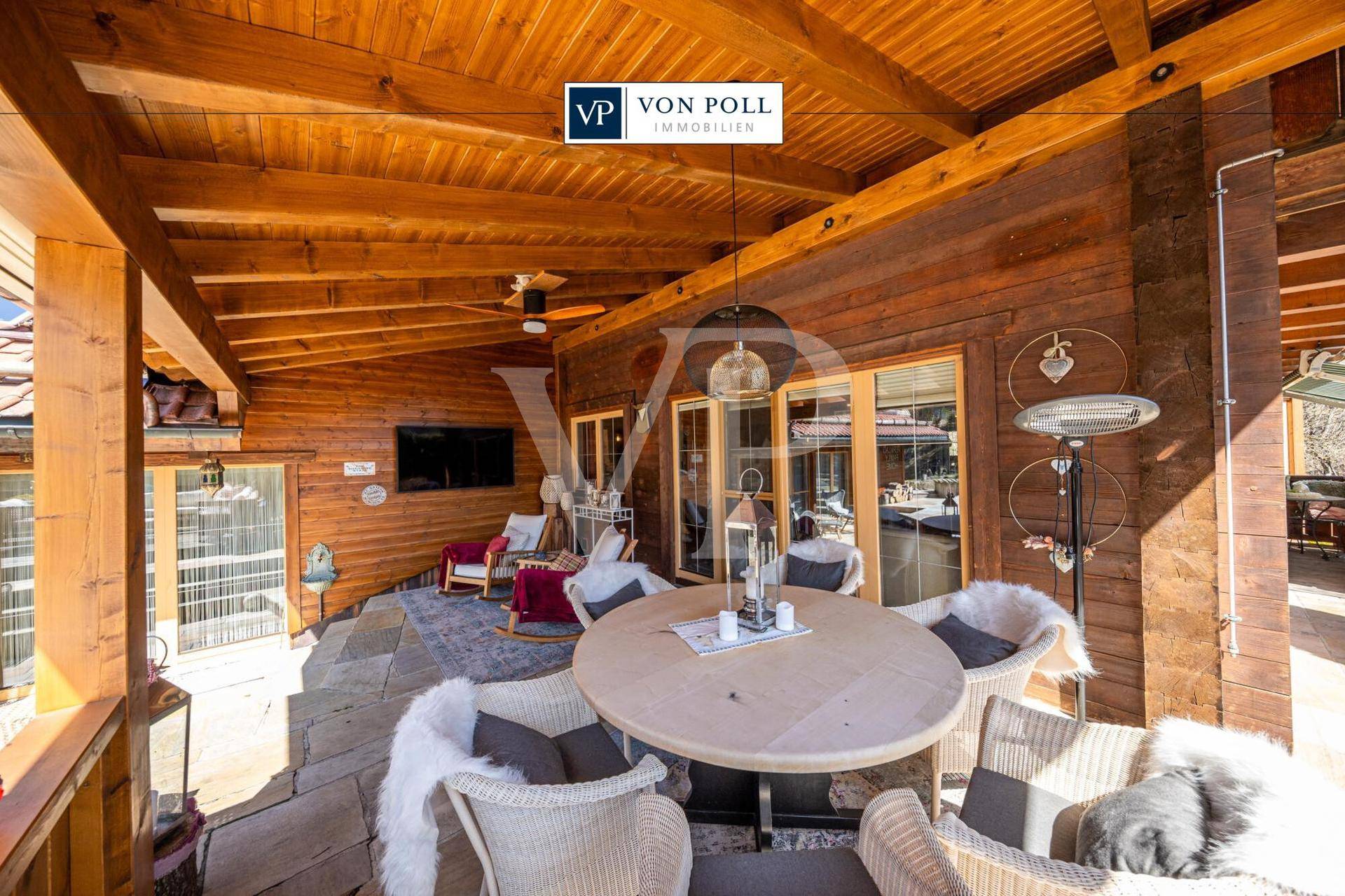 Überdachte Terrasse mit Holzbalkendecke, Esstisch und gemütlichen Lounge-Möbeln für entspannte Stunden.