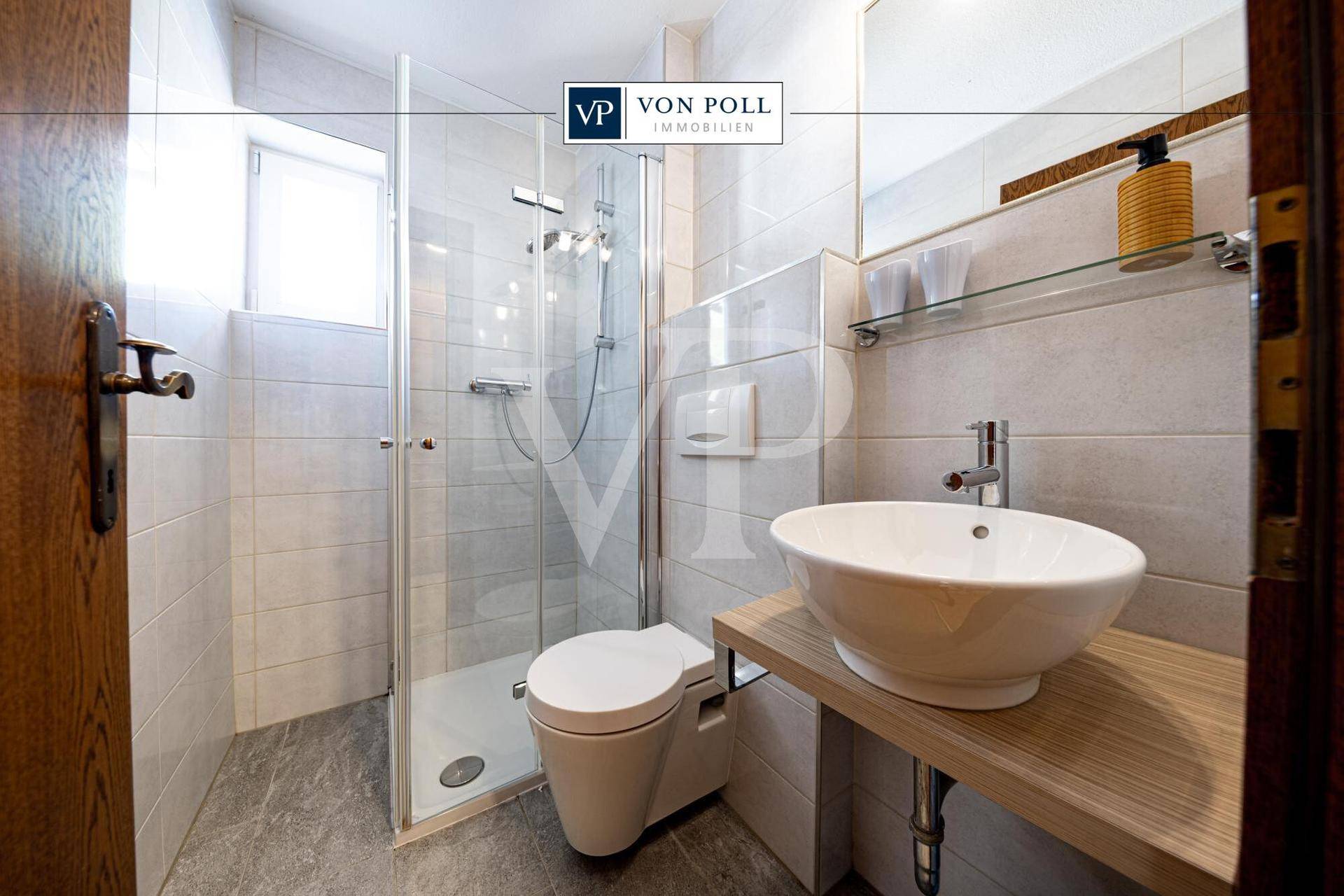 Modernes Badezimmer mit Duschkabine, wandhängendem WC und Fenster für Tageslicht.