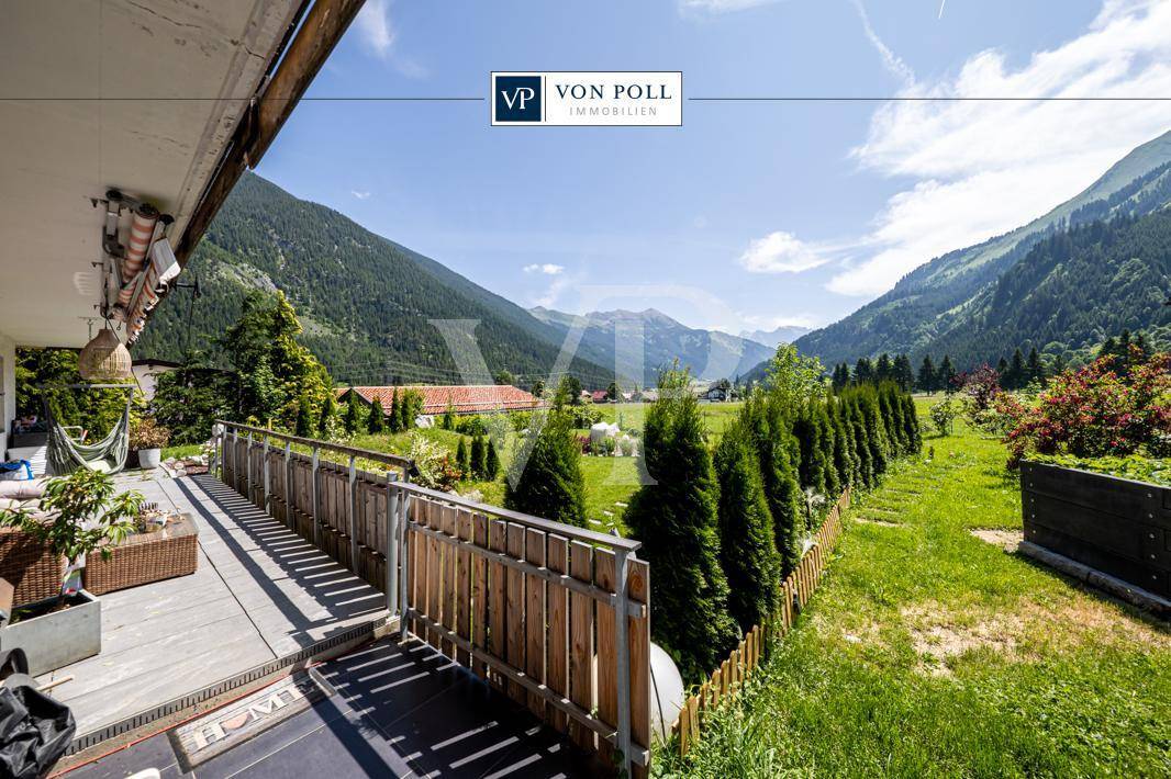 Geräumige Terrasse mit Holzboden und atemberaubendem Blick auf die umliegende Berglandschaft.