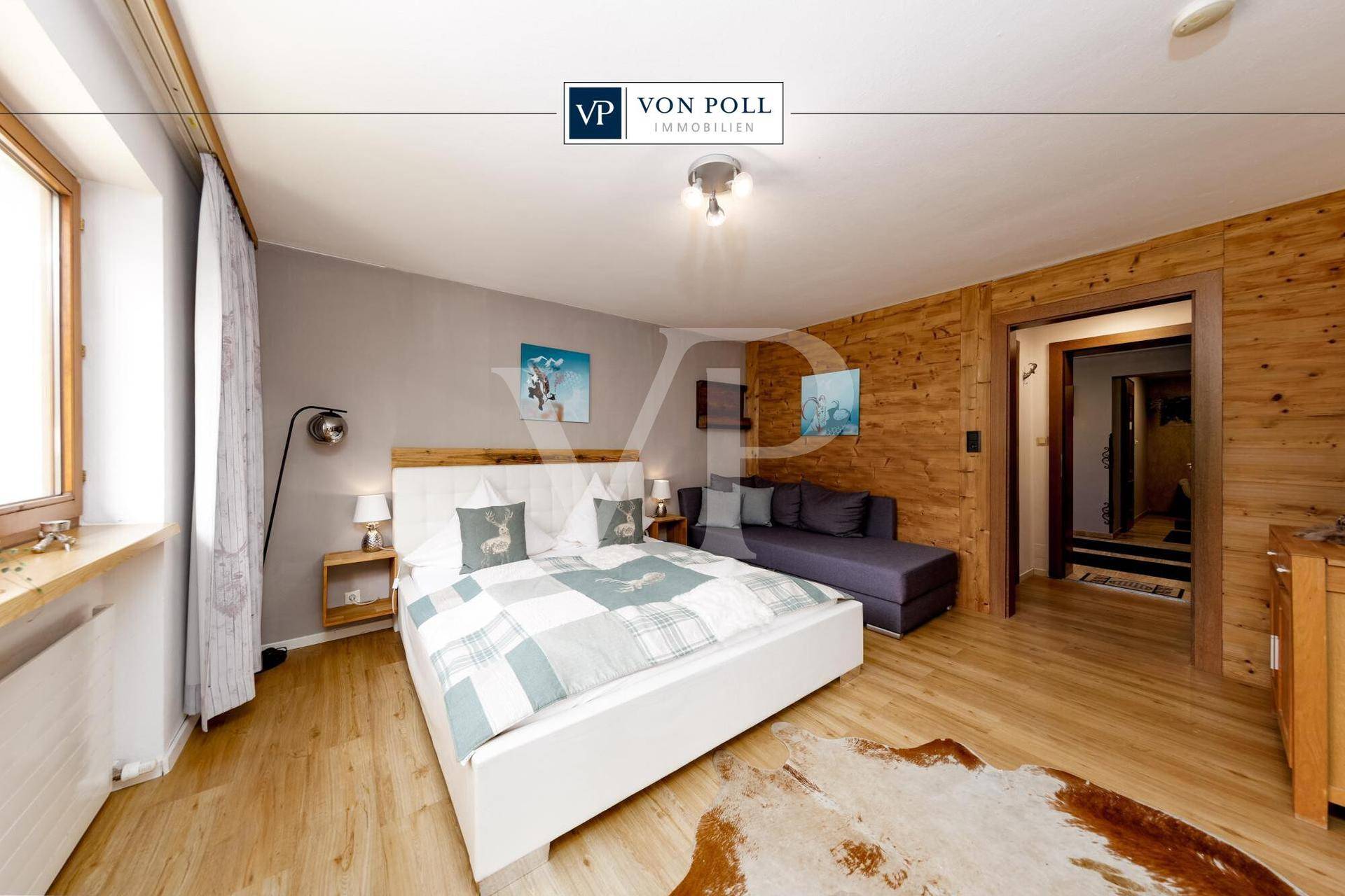 Gemütliches Schlafzimmer mit Holzwänden, Doppelbett und rustikalen Dekorationselementen.