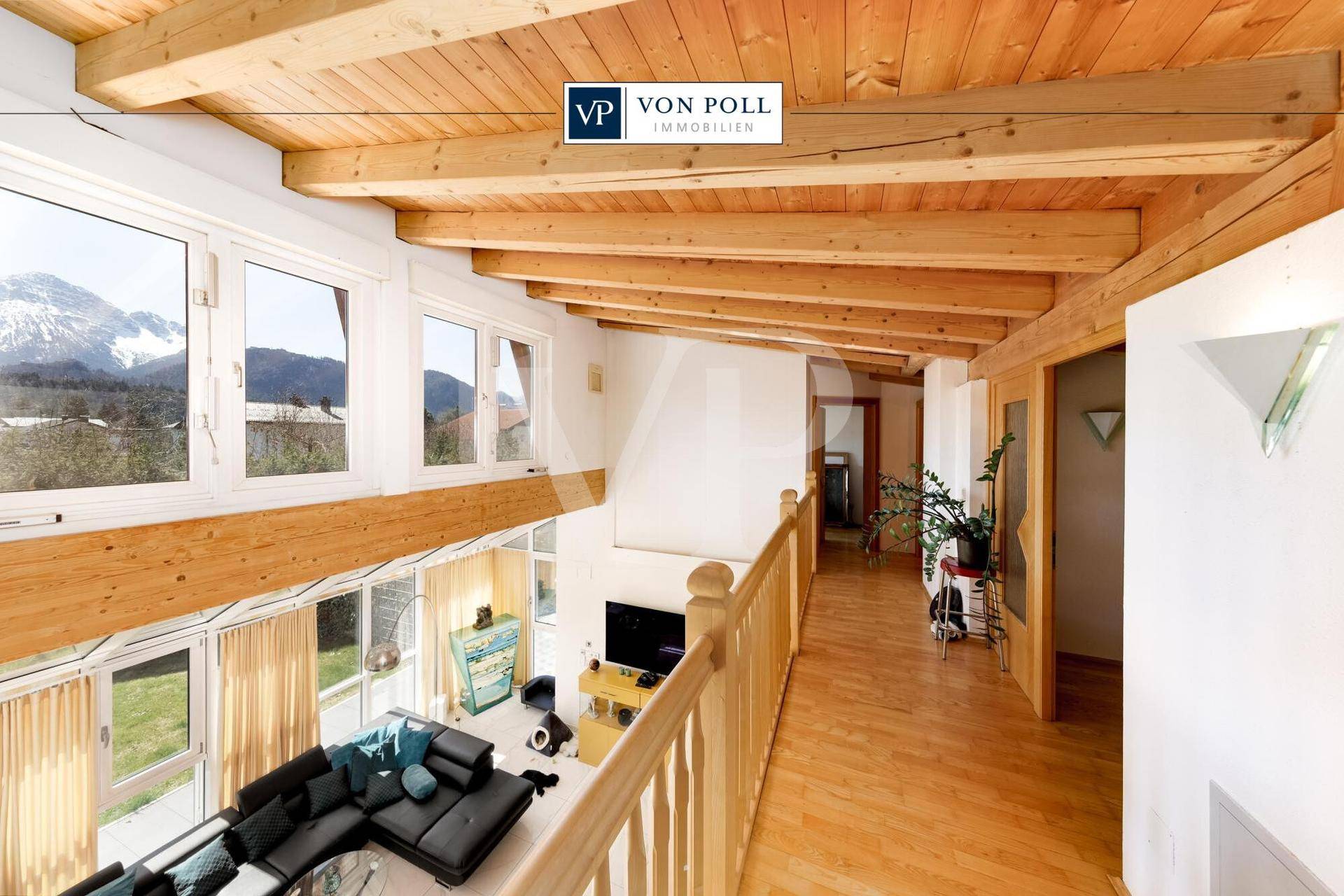Galeriebereich im Obergeschoss mit Holzboden, freiliegenden Balken und Bergblick.
