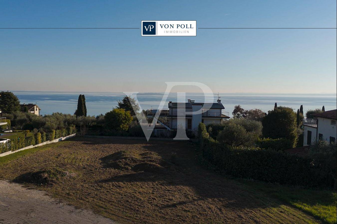 Freies Grundstück mit weitem Blick auf den See und die umliegende mediterrane Vegetation.