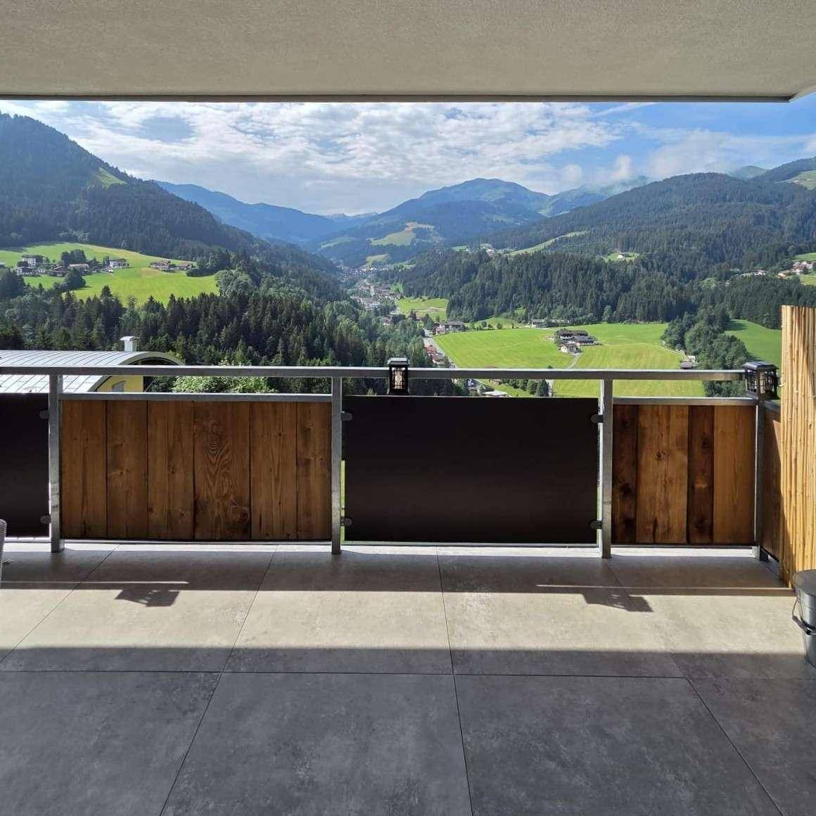 Geräumiger Balkon mit Fliesenboden und atemberaubendem Panoramablick auf die Alpen.