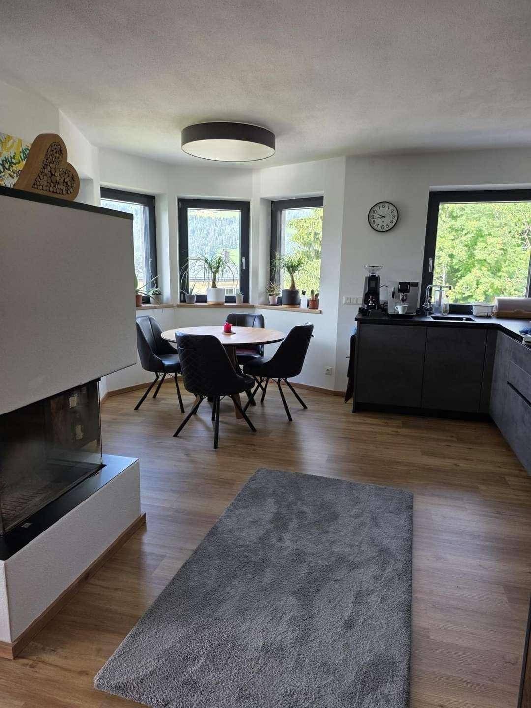 Heller Essbereich mit Holztisch, modernen Stühlen und großen Fenstern mit Ausblick.