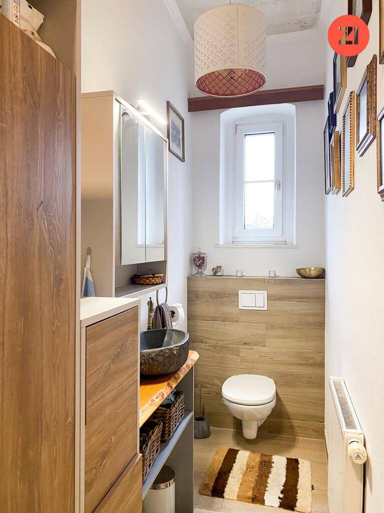 Modernes Gäste-WC mit Holzverkleidung, wandhängendem WC, Einzelwaschbecken und Fenster.