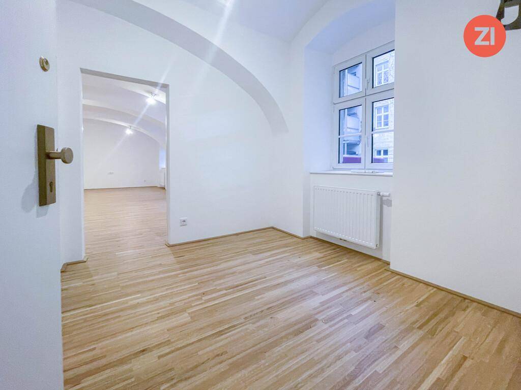 Eingangsbereich oder Flur mit hellem Holzfußboden, weiß gestrichenen Wänden und einem Fenster.