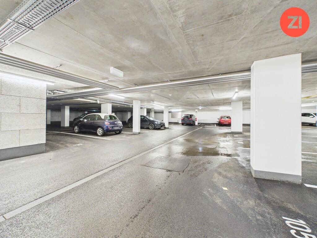 Tiefgarage mit mehreren Stellplätzen und Betonwänden in einem Neubau.