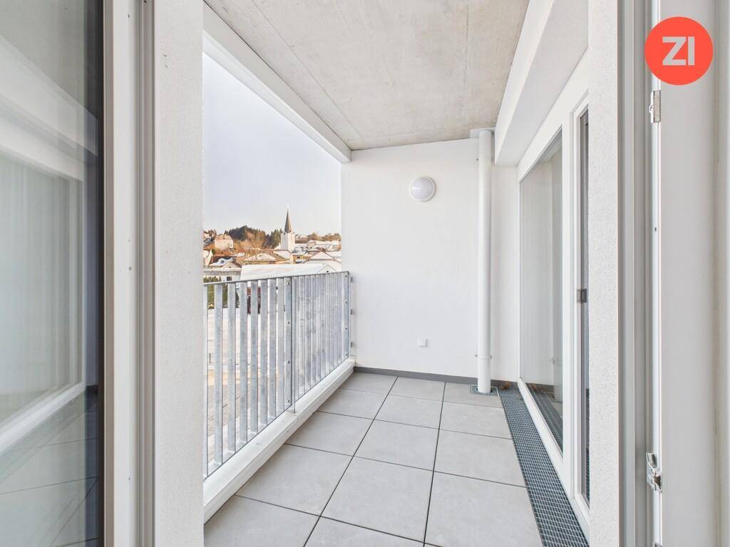 Balkon mit Fliesenboden und Blick auf die Stadt und umliegende Gebäude.