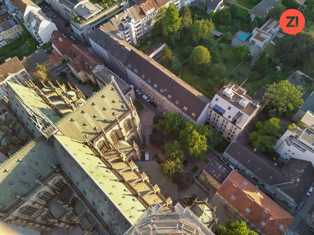 Luftaufnahme einer Stadtansicht mit einem großen historischen Kirchengebäude und umliegenden Häusern.