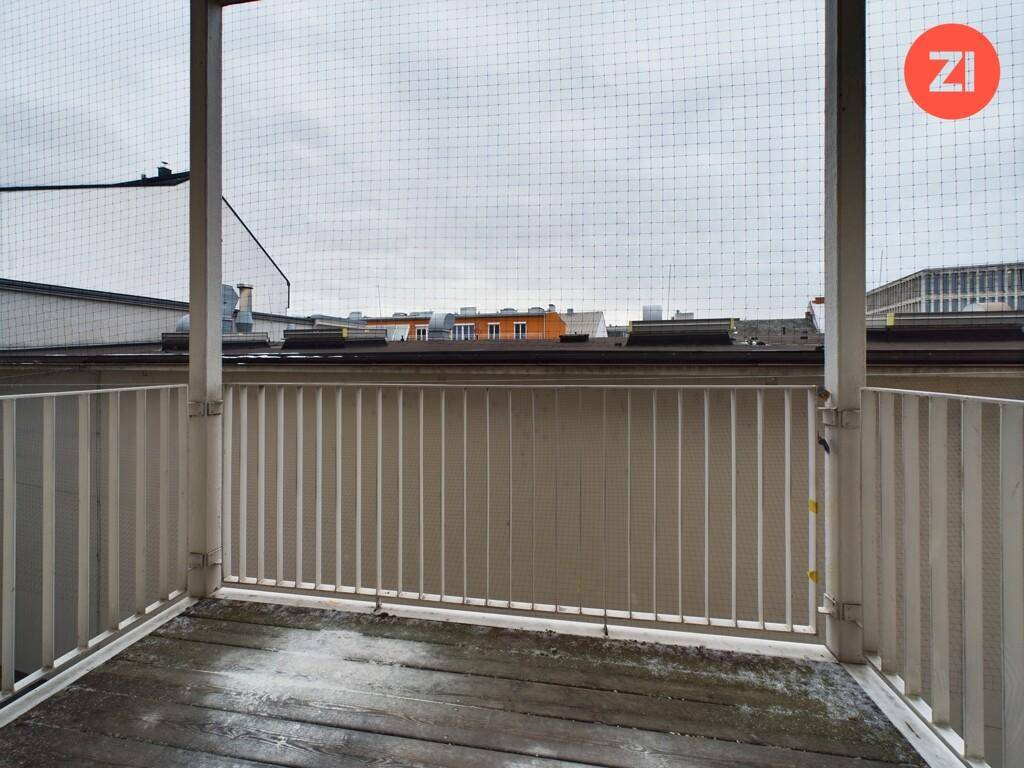 Kleiner Balkon mit Gittergeländer und Blick auf die umliegenden Gebäude, ideal für frische Luft.