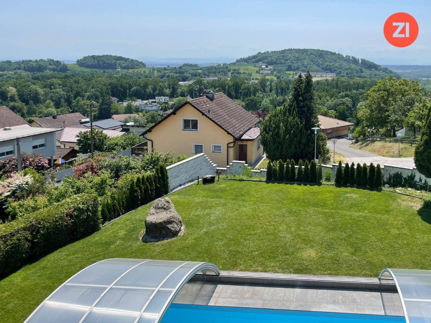 Weitläufiger Garten mit Pool und Panoramablick auf die hügelige Landschaft.