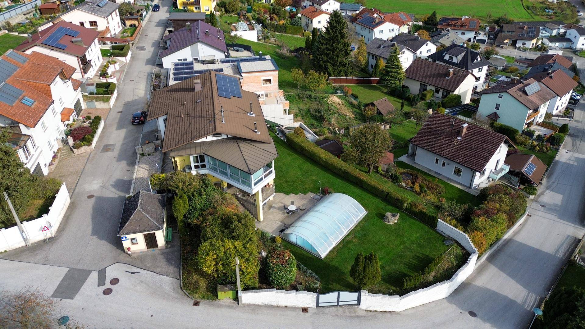 Weitläufige Luftaufnahme des Anwesens mit Pool, Garten und angrenzender Wohnbebauung.