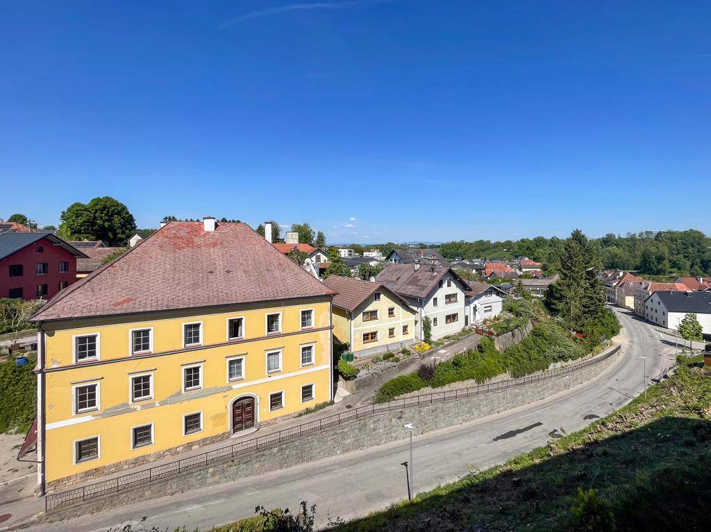 Panoramablick über eine Stadt mit verschiedenen Häusern und einer Straße unter blauem Himmel.