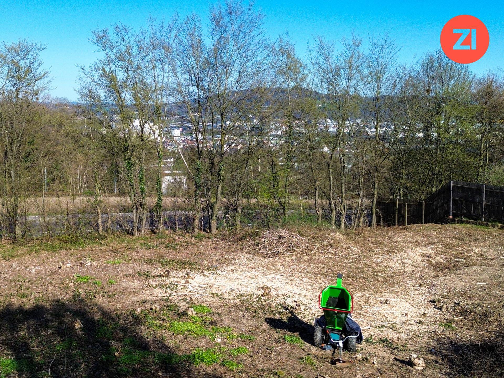Gerodetes Grundstück mit Bäumen im Hintergrund und Blick auf die weitere Umgebung.