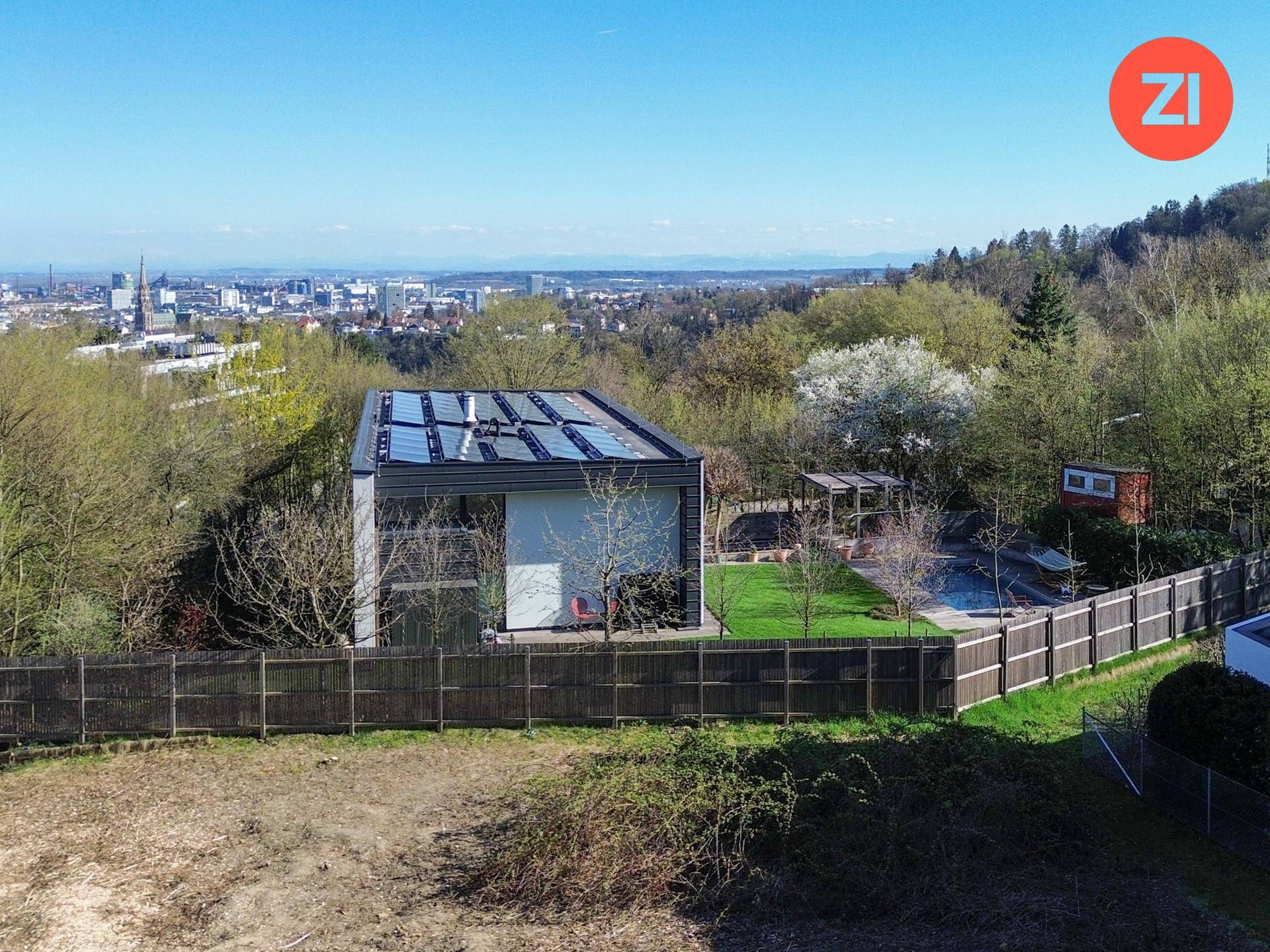 Moderner Neubau mit Solaranlage, gepflegtem Garten und weitem Blick über die Stadt.