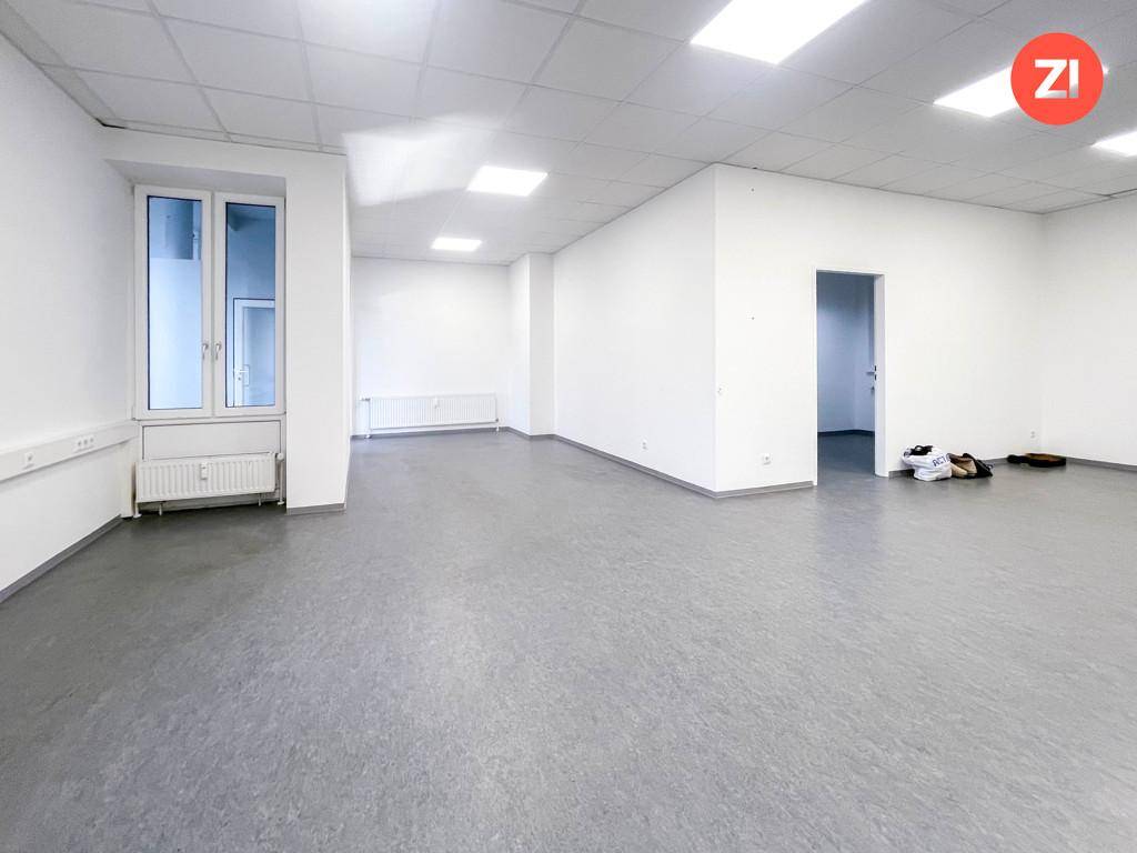 Großer, heller Büroraum mit grauen Vinylböden und quadratischen Deckenleuchten.