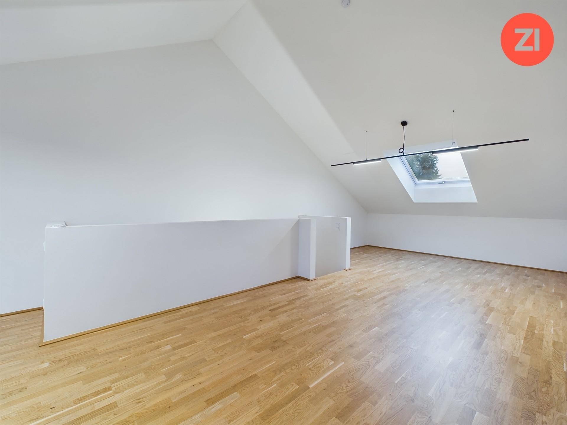 Dachboden mit Holzboden, Dachschrägen und einem großen Dachfenster.