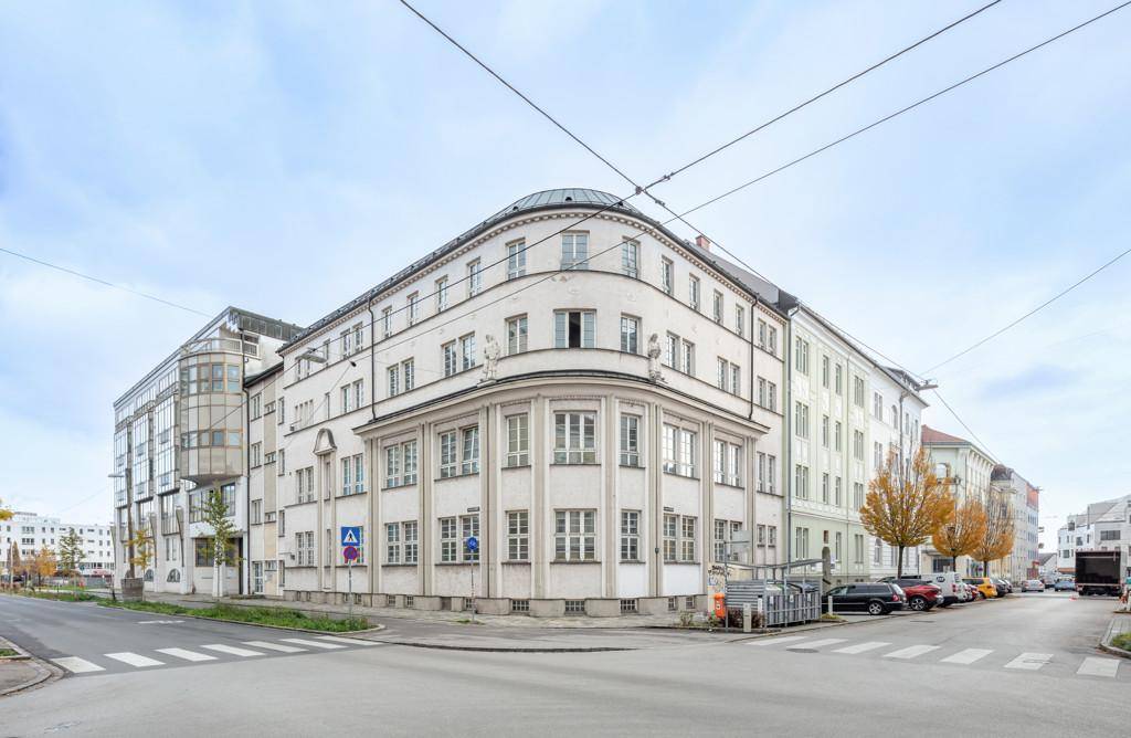 Das Eckgebäude präsentiert sich mit seiner markanten Architektur an einer belebten Straßenkreuzung.