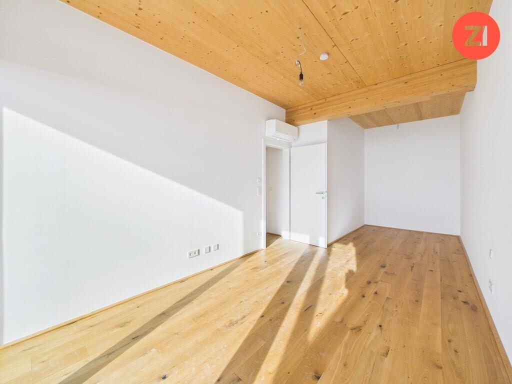 Geräumiges, unmöbliertes Zimmer mit Holzboden und weißer Wandfarbe, bereit zur individuellen Einrichtung.