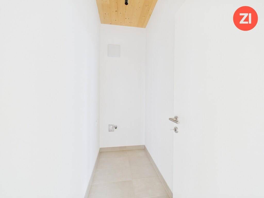 Schmaler Raum mit Fliesenboden und weiß gestrichenen Wänden, möglicherweise als Abstellraum nutzbar.